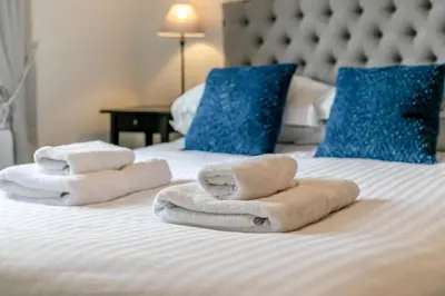 a hotel room with towels on a bed with blue pillows at 3 Bed in Fowey oc-s33234 in Fowey