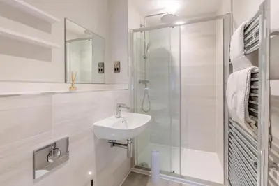 a white bathroom with a sink and a shower at 3 Bed in Fowey oc-s33234 in Fowey