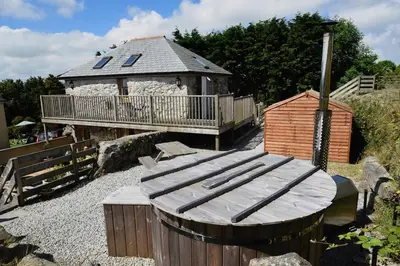 a wooden bench sitting in front of a building at The Mowhay tranquil farm stay with views in Redruth