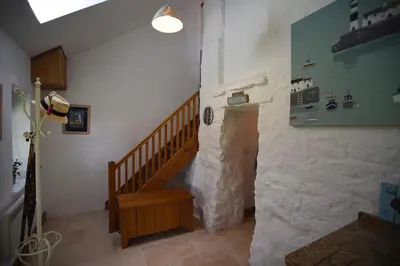 a staircase in a room with a stone wall at The Mowhay tranquil farm stay with views in Redruth
