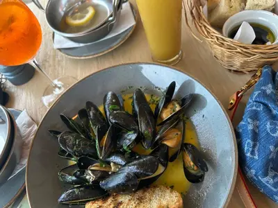 a plate of mussels and bread on a table at The Mowhay tranquil farm stay with views in Redruth