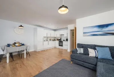 a living room with a couch and a dining room at 12 Ocean One in Newquay