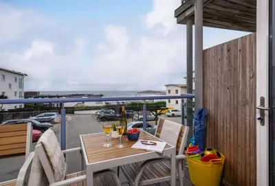 a balcony with a table and glasses of wine at 12 Ocean One in Newquay