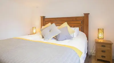 a bedroom with a white bed with two lamps on it at Doolittle in Porthleven