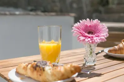 a table with a plate of food and a glass of orange juice at Doolittle in Porthleven