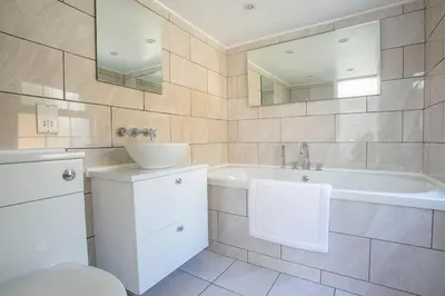 a white bathroom with a tub and a sink at Doolittle in Porthleven
