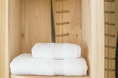 a stack of white towels sitting on a shelf at Doolittle in Porthleven