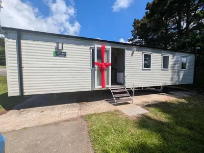a mobile home with a red bow on it at Willows Way Parkdean Newquay in Porth