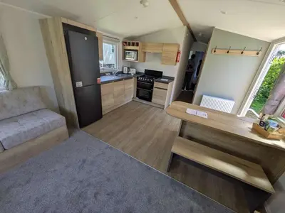 a small kitchen and living room in a tiny house at Willows Way Parkdean Newquay in Porth