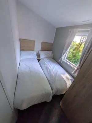 a bedroom with two beds and a window at Willows Way Parkdean Newquay in Porth