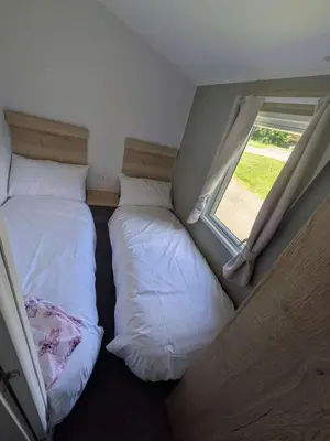 two beds in a small room with a window at Willows Way Parkdean Newquay in Porth