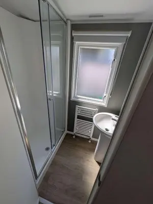 a bathroom with a sink and a mirror and a window at Willows Way Parkdean Newquay in Porth