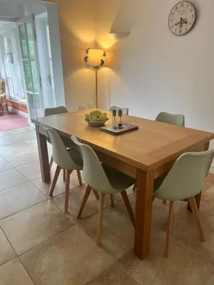 a wooden table with chairs and a plate of fruit on it at Tamarin in Truro