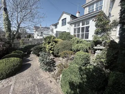 a garden in front of a house with bushes at Tamarin in Truro