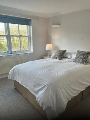 a bedroom with a large white bed with a window at Tamarin in Truro