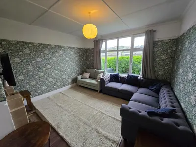 a living room with a couch and a window at Lowenek House in Perranporth