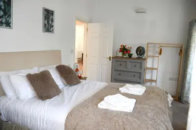 a bedroom with a white bed with towels on it at Sweetpea - Near Newquay - a tranquil hideaway in Saint Dennis