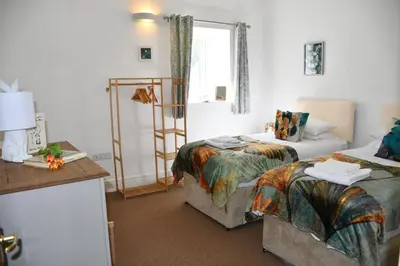 a hotel room with two beds and a window at Sweetpea - Near Newquay - a tranquil hideaway in Saint Dennis