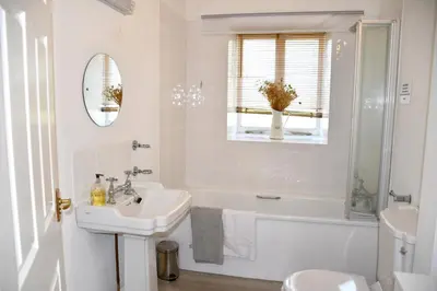 a white bathroom with a sink and a tub and a toilet at Sweetpea - Near Newquay - a tranquil hideaway in Saint Dennis