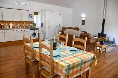a kitchen and living room with a table and chairs at Sweetpea - Near Newquay - a tranquil hideaway in Saint Dennis