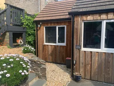 a wooden shed with a cat in the window at The Lodge in Truro