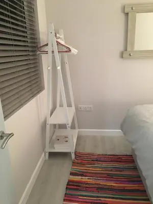 a white ladder in a room with a bed and a rug at The Lodge in Truro