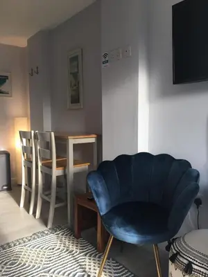 a living room with a blue chair and a table at The Lodge in Truro