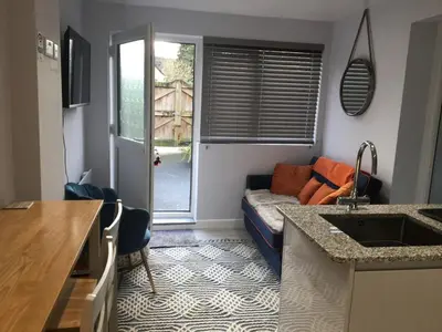 a living room with a couch and a kitchen at The Lodge in Truro