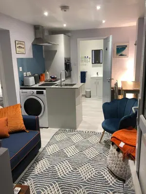 a kitchen and living room with a blue couch at The Lodge in Truro