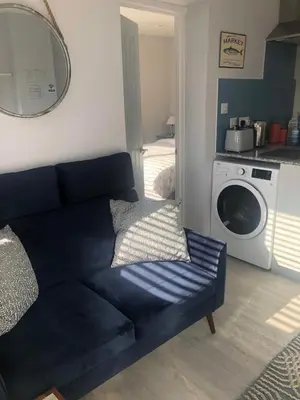 a living room with a couch and a washing machine at The Lodge in Truro