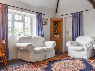 a living room with two white chairs and a rug at Nutmeg's - Uk50373 in Camelford