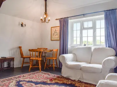 a living room with a white couch and a table at Nutmeg's - Uk50373 in Camelford