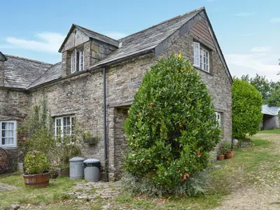 an old stone house with a tree in front of it at Nutmeg's - Uk50373 in Camelford