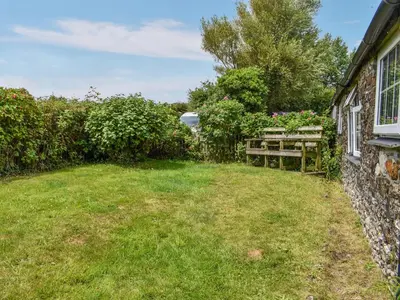 a garden with a bench next to a house at Skyber - Uk50374 in Camelford