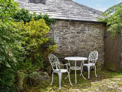 a table and chairs in front of a brick building at Skyber - Uk50374 in Camelford