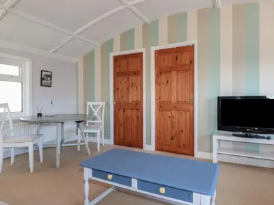 a living room with a table and a tv at The Loft in Truro