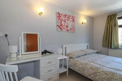 a bedroom with a bed and a dresser with a mirror at The Loft in Truro