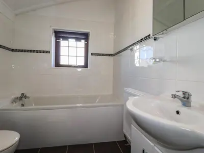 a white bathroom with a tub and a sink at The Loft in Truro