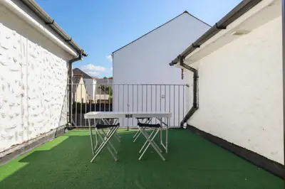 a picnic table on the balcony of a building at The Loft in Truro