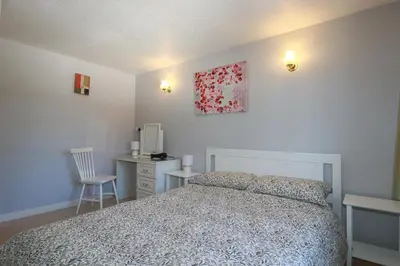 a bedroom with a bed and a desk and a chair at The Loft in Truro