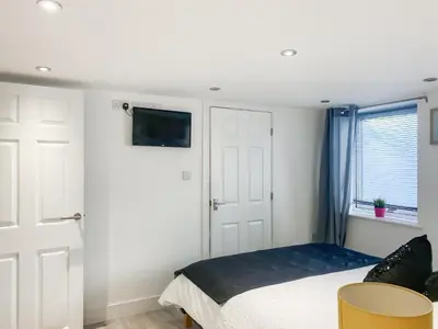 a bedroom with a bed and a tv on the wall at The Loft - Uk50517 in Falmouth
