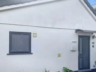 a white building with a window and a door at The Loft - Uk50517 in Falmouth