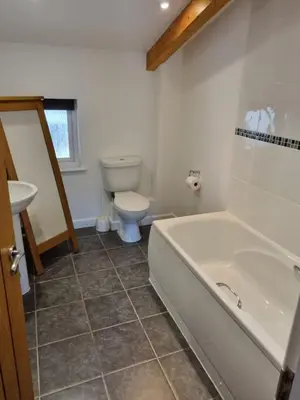 a bathroom with a tub and a toilet and a sink at Towan Valley, Porthtowan - Coastal 3 Bedroom Eco-Home with Hot Tub in Truro