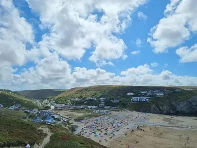 a beach with a bunch of people on it at Towan Valley, Porthtowan - Coastal 3 Bedroom Eco-Home with Hot Tub in Truro