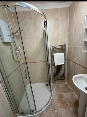 a bathroom with a shower and a sink at Pirans Apartments in Perranporth