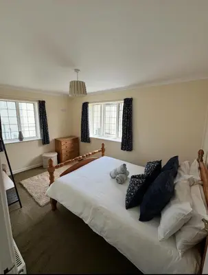 a bedroom with a bed with a stuffed animal on it at Pirans Apartments in Perranporth
