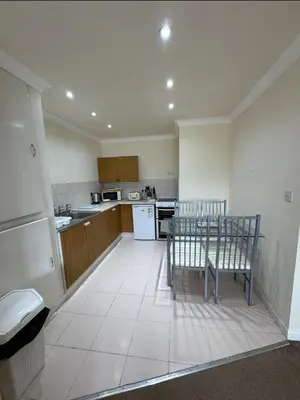 a kitchen with a table and chairs in it at Pirans Apartments in Perranporth