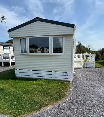 a small house with a window and a white fence at L20 at Seven Bays Park in St Merryn
