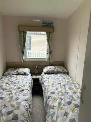 two beds in a small room with a window at L20 at Seven Bays Park in St Merryn