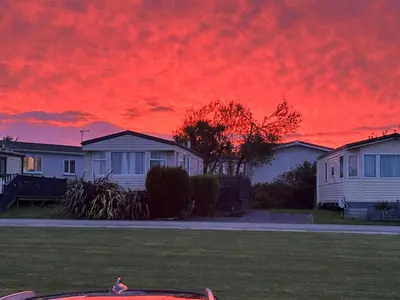 a red sky at sunset with houses and a car at L20 at Seven Bays Park in St Merryn